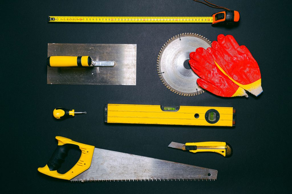 A set of construction hand tools arranged in a flat lay on a dark background. Ideal for DIY projects.